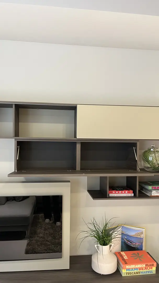 Soggiorno con pannello TV girevole Vision e libreria orizzontale Alias con anta scorrevole