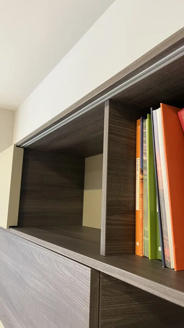 Soggiorno con pannello TV girevole Vision e libreria orizzontale Alias con anta scorrevole